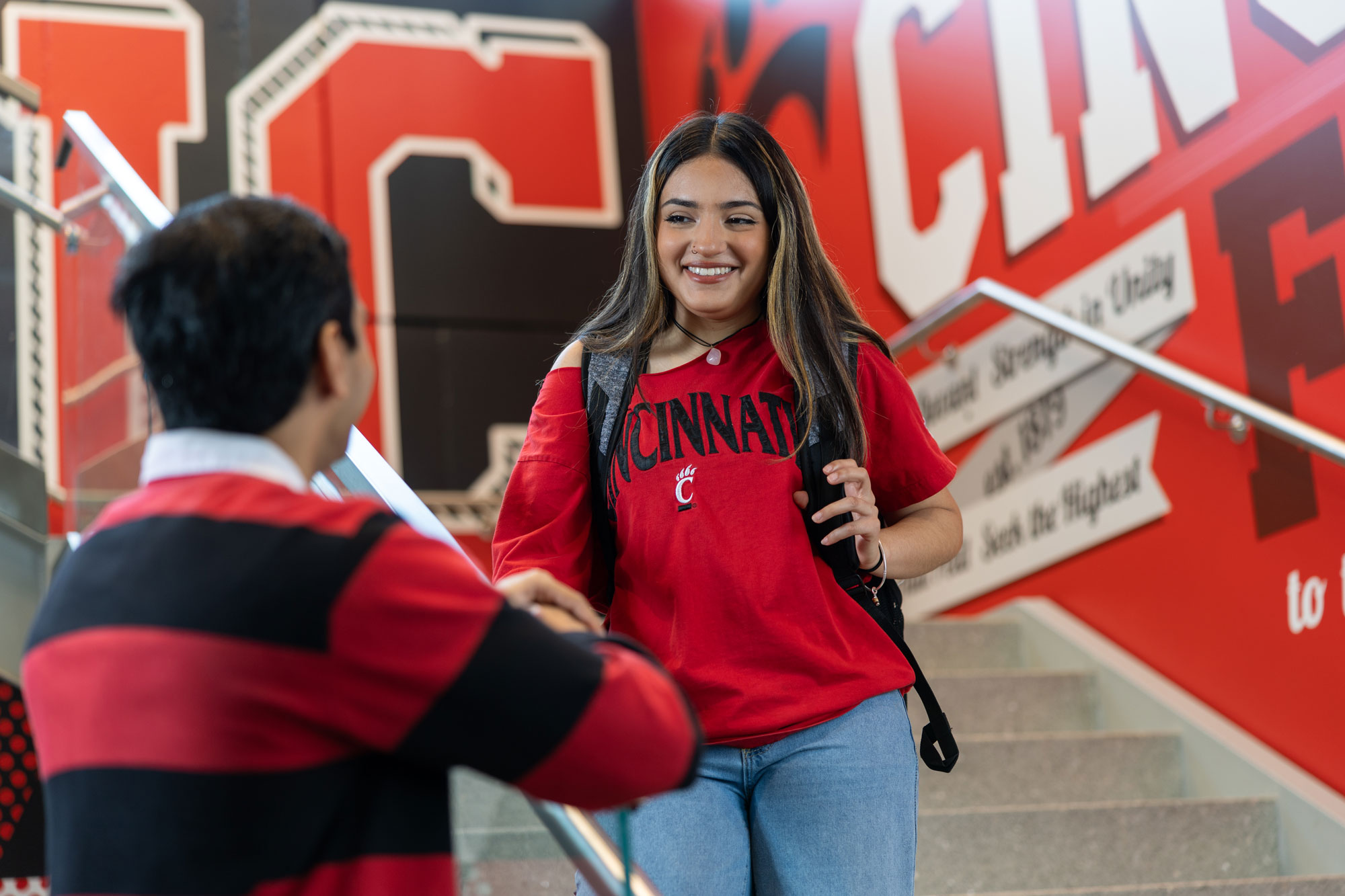 Two University of Cincinnati students converse in a stairwell