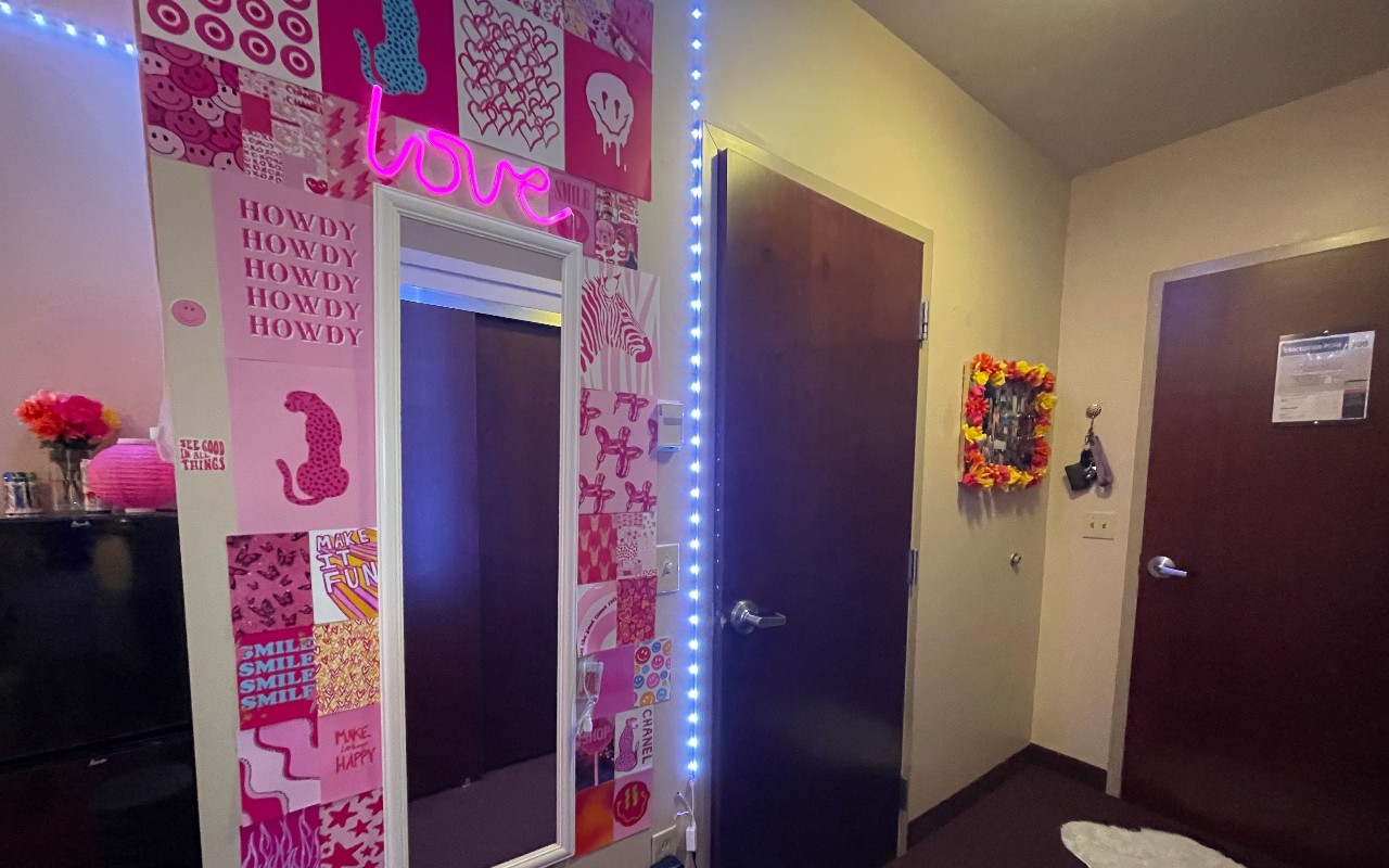 Wall of bedroom decorated in graphics and esigns in pink, red and yellow wiht light strips.