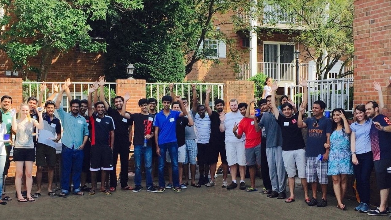 A group of about a dozen graduate student residents gathered in front of the Senator Place apartments.
